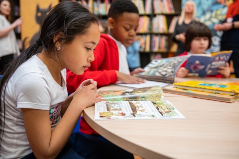 children reading books at table